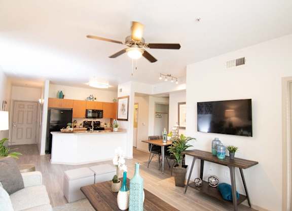 a living room and kitchen with a ceiling fan