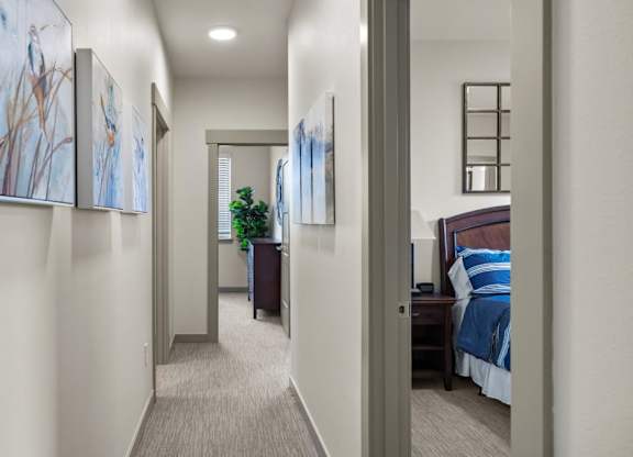 A hallway with a bedroom at the end.