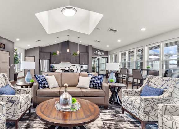 A living room with a brown sofa, two armchairs, and a coffee table.