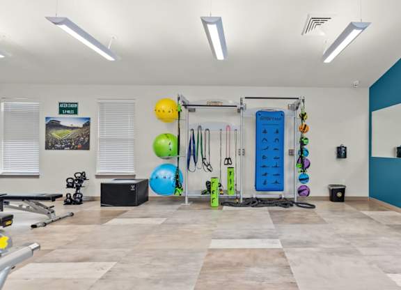 A gym with a variety of equipment including a squat rack, a bench, and a mirror.