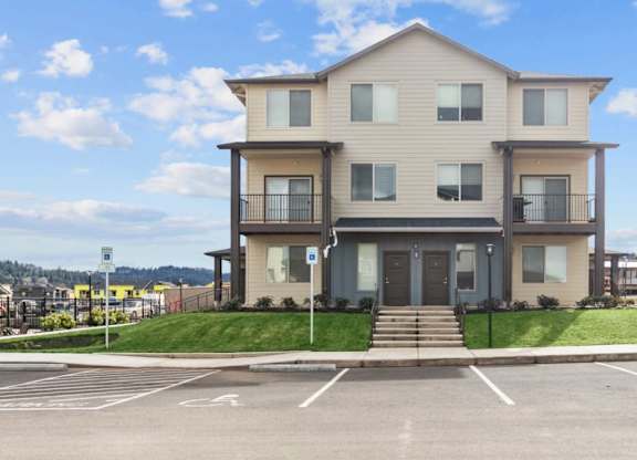 A two-story building with a parking lot in front.