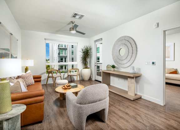 A living room with a brown couch, a grey armchair, and a coffee table.