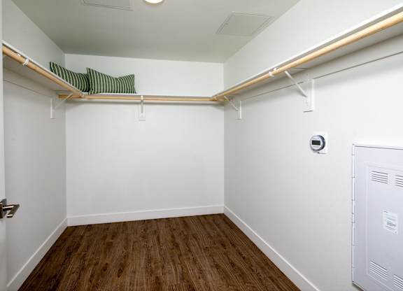 A small, empty room with a white door and a white electrical box on the wall.