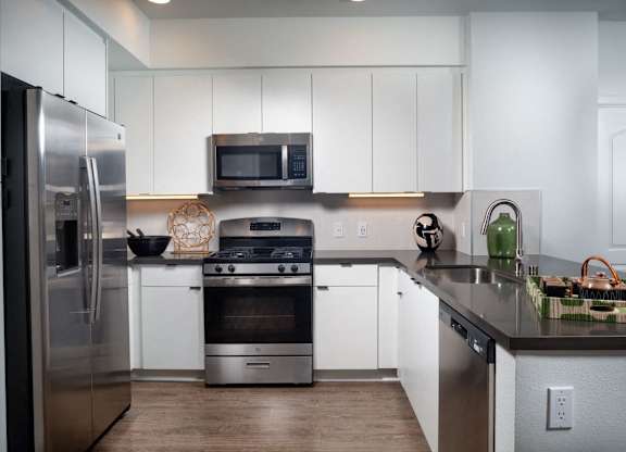 A modern kitchen with stainless steel appliances and white cabinets.