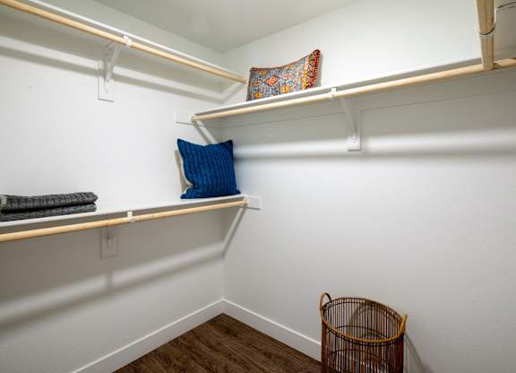 A small room with a shelf and a basket on the floor.