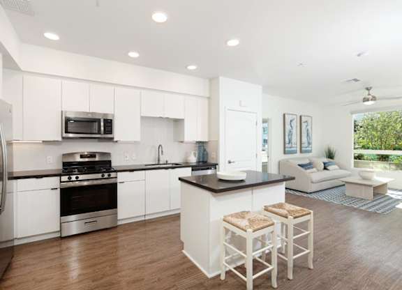 A modern kitchen with white cabinets and a black countertop.
