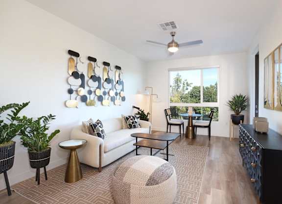 A living room with a white couch, a coffee table, and a large window.