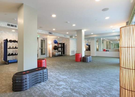 A room with a white wall and a grey carpet.