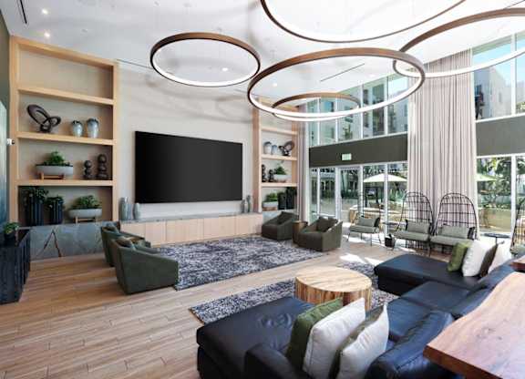 A modern living room with a large couch, a coffee table, and a TV.
