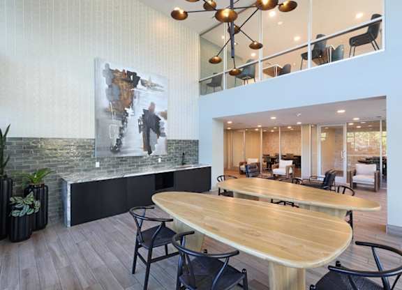 A modern dining area with a wooden table and chairs.