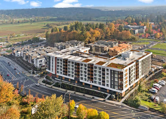 A large building with a parking lot in front of it at Cru at Willows Apartments, Redmond, WA, 98052