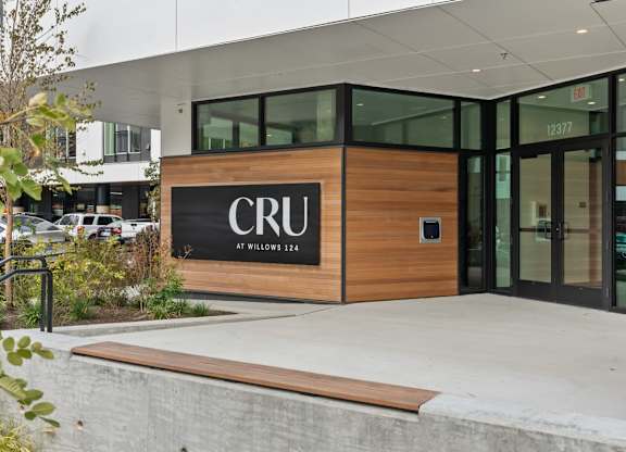 The front of a building with the letters CRU on it at Cru at Willows Apartments, Redmond, 98052