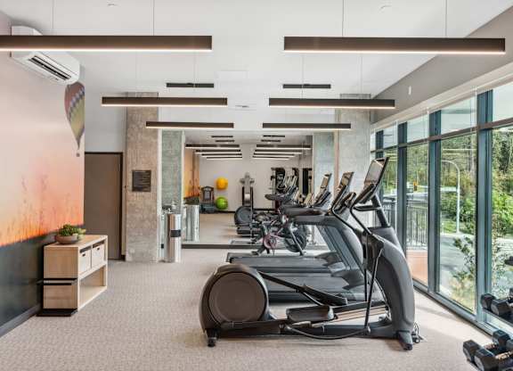 A gym with treadmills and exercise equipment at Cru at Willows Apartments, Washington