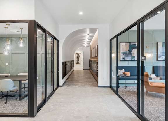 A hallway with glass doors and a carpeted floor at Cru at Willows Apartments, Washington
