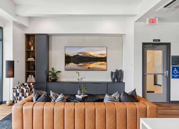 A living room with a brown sofa and a painting on the wall at Cru at Willows Apartments, Redmond, WA