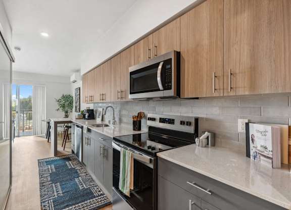A modern kitchen with a black stove top oven and a microwave above it at Cru at Willows Apartments, Redmond, 98052