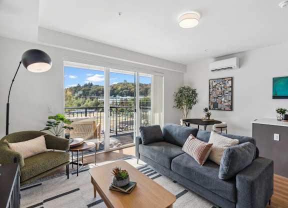 A living room with a grey couch and a wooden coffee table at Cru at Willows Apartments, Redmond, Washington, 98052