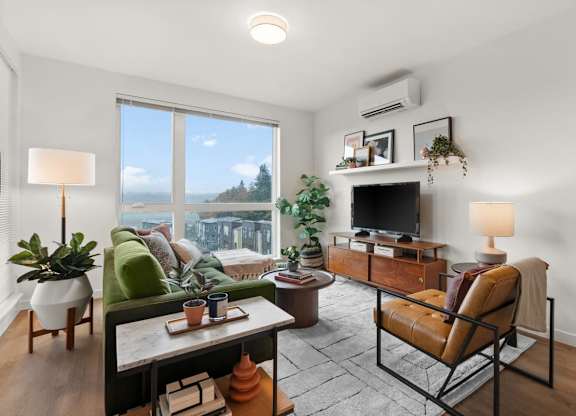 A living room with a couch, chair, and potted plants at Cru at Willows Apartments, Redmond, WA, 98052