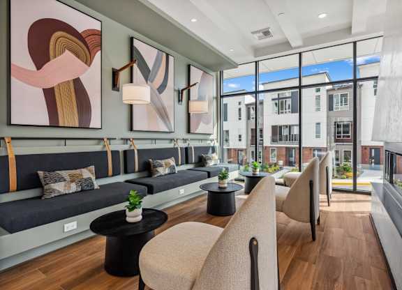 A modern living room with a large window and a view of a building outside at Cru at Willows Apartments, Redmond, 98052