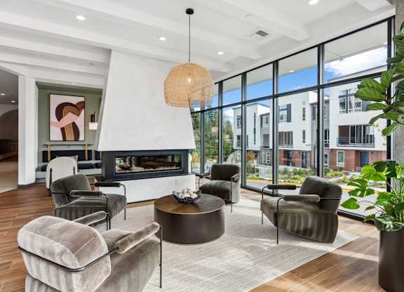 A modern living room with a fireplace and comfortable seating at Cru at Willows Apartments, Redmond, WA, 98052