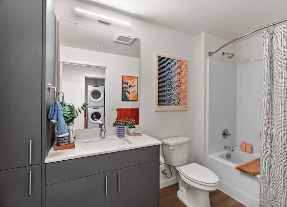 A bathroom with a toilet, sink, and shower at Cru at Willows Apartments, Redmond, WA
