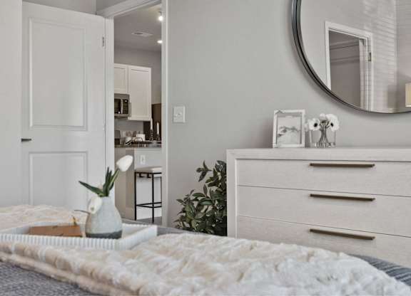 A bedroom with a bed, dresser, and mirror.