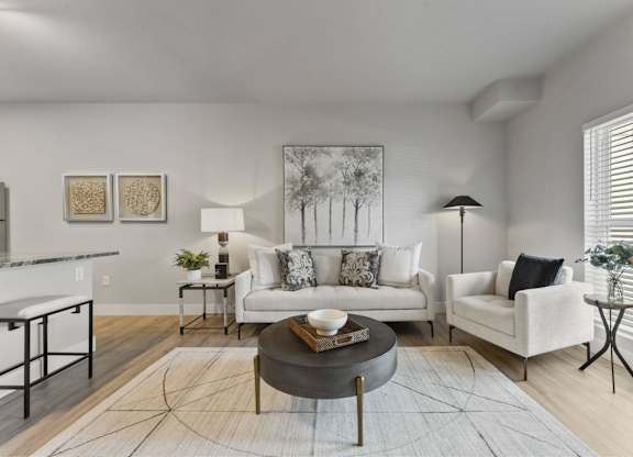 A living room with a white couch, a coffee table, and a painting on the wall.
