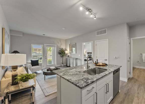 A modern kitchen with a marble countertop and stainless steel appliances.