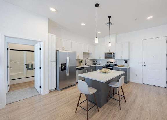 A modern kitchen with a dining table and chairs.