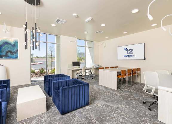 A modern office space with blue chairs and a whiteboard with the number 12 on it.