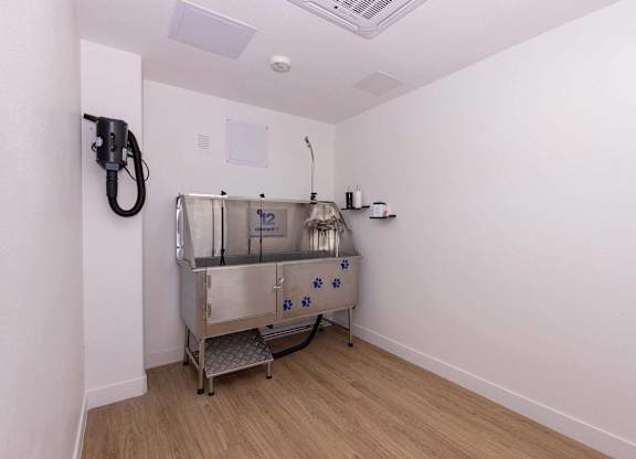 A clean, empty room with a stainless steel sink and faucet.