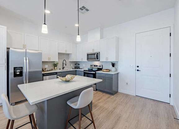 A kitchen with a table and chairs.