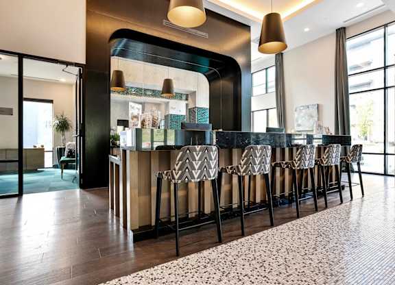 A bar area with a black counter and a patterned rug.
