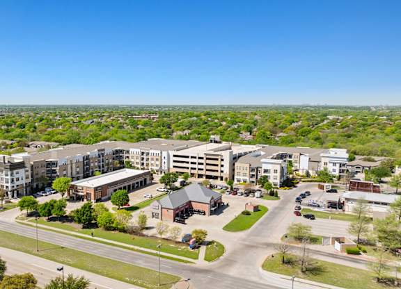 A view of a residential area with apartment buildings and a parking lot.