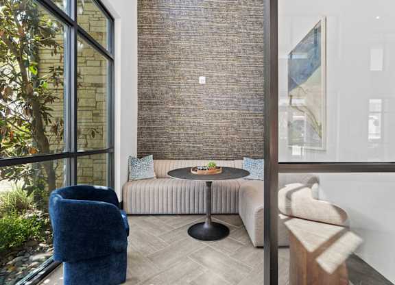 A living room with a blue chair and a round table.