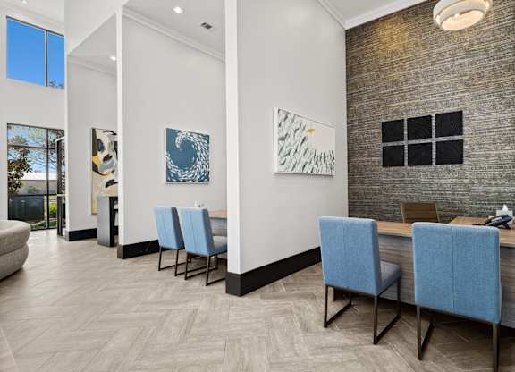 A room with a long table and blue chairs.