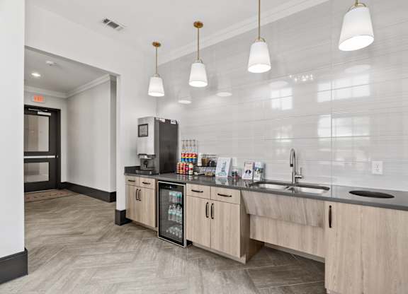 A kitchen with a refrigerator, sink, and cabinets.
