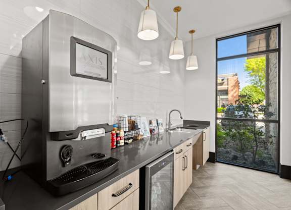 A modern kitchen with a large window overlooking a tree.