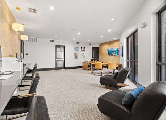 A waiting area with black leather chairs and a white reception desk.