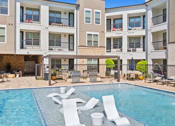 A swimming pool in front of apartment buildings.