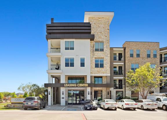 A modern building with a leasing center sign in front.