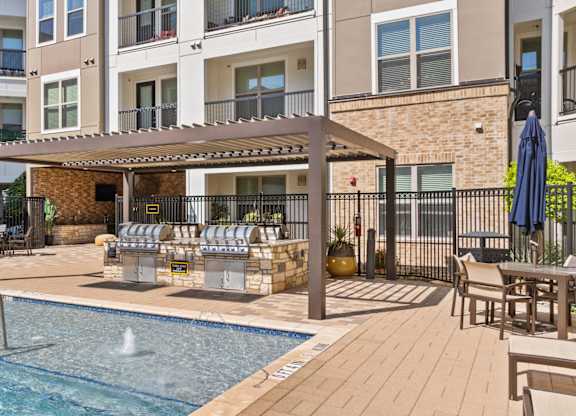 A pool area with a hot tub and a building in the background.