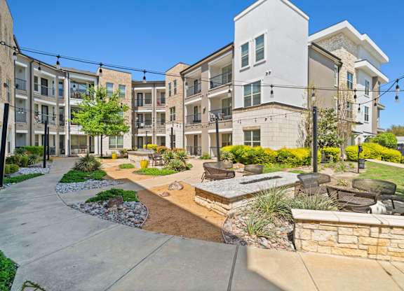 A sunny day at a modern apartment complex with a well-maintained courtyard.