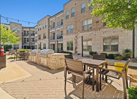 A sunny day at a courtyard with a table and chairs.