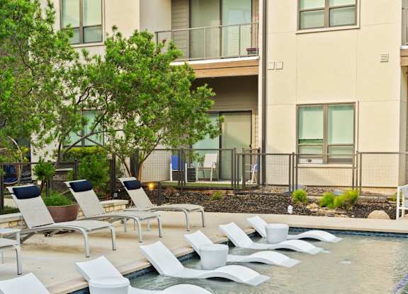 A pool with white chairs and a blue line in the middle.