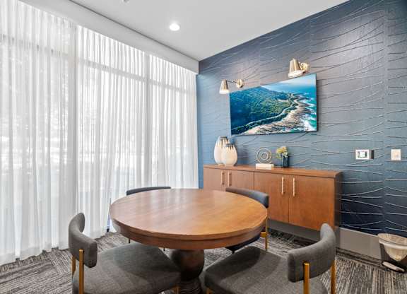 A conference room with a wooden table surrounded by chairs.