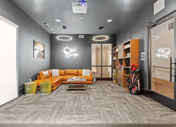 A modern office space with a grey carpet and a grey wall with a white light bulb decoration.