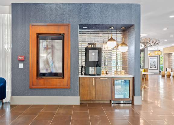 A reception area with a blue chair and a framed picture on the wall.