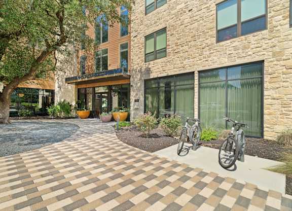 A courtyard with a brick patterned floor and a bicycle.