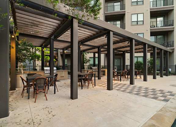 A patio with a table and chairs under a roof.